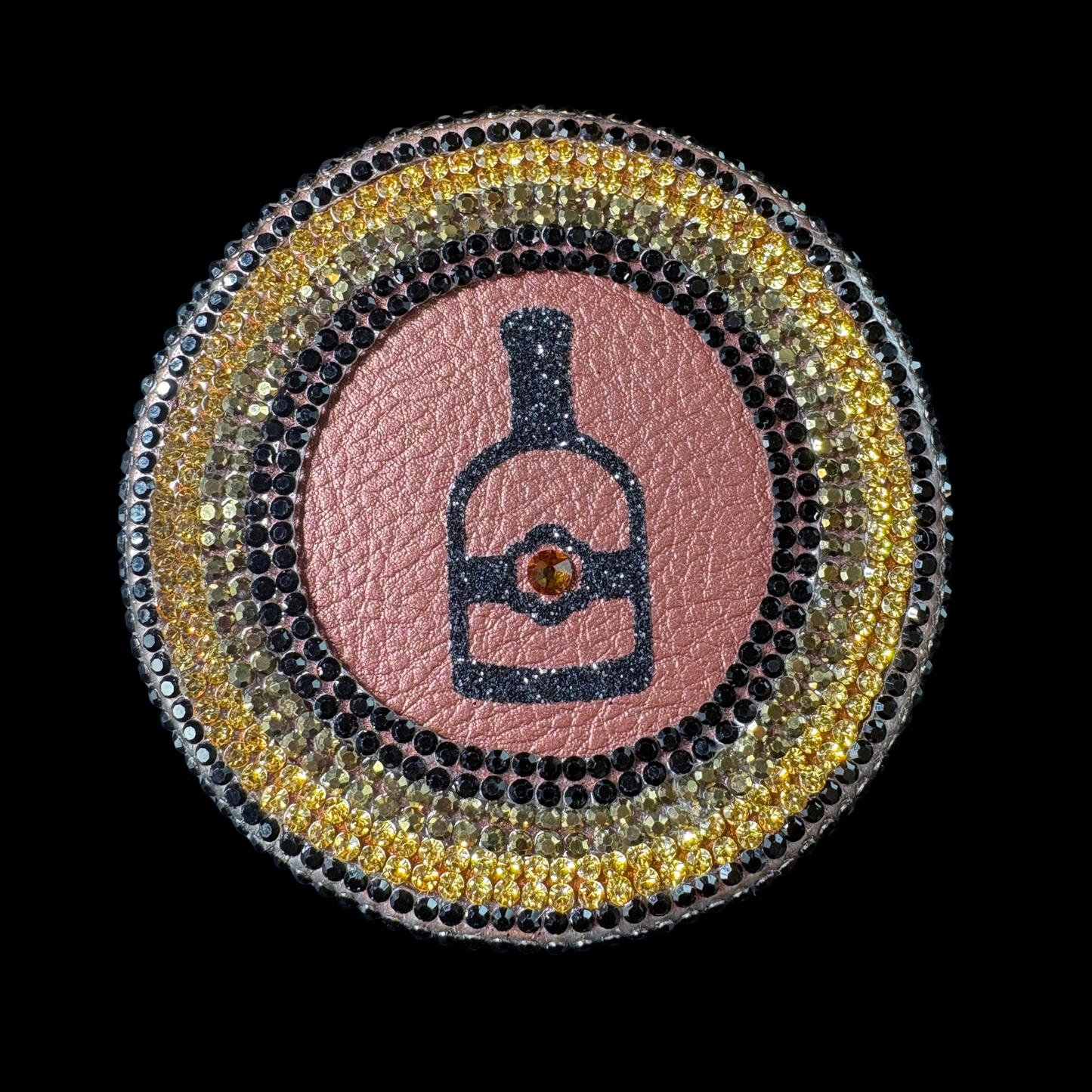 Decorative patch with a bottle design on a pink background, surrounded by a circular border of stones.