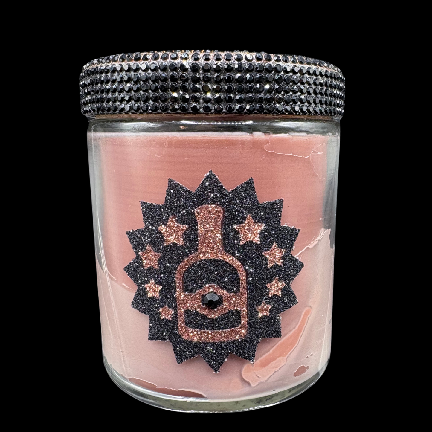Small glass jar with decorative lid and pink label featuring a bottle design.