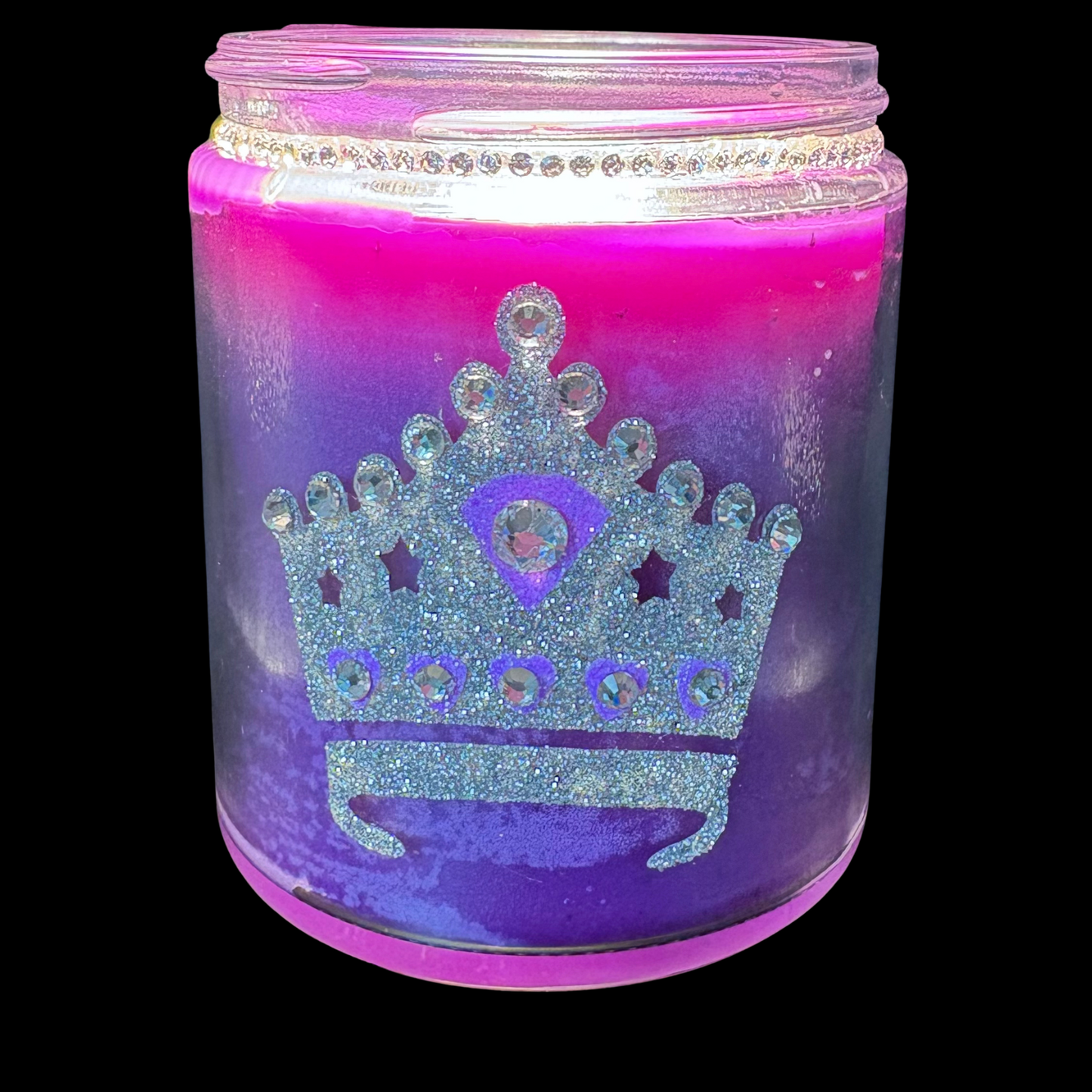 Candle in a jar with a glittery crown design on a black background
