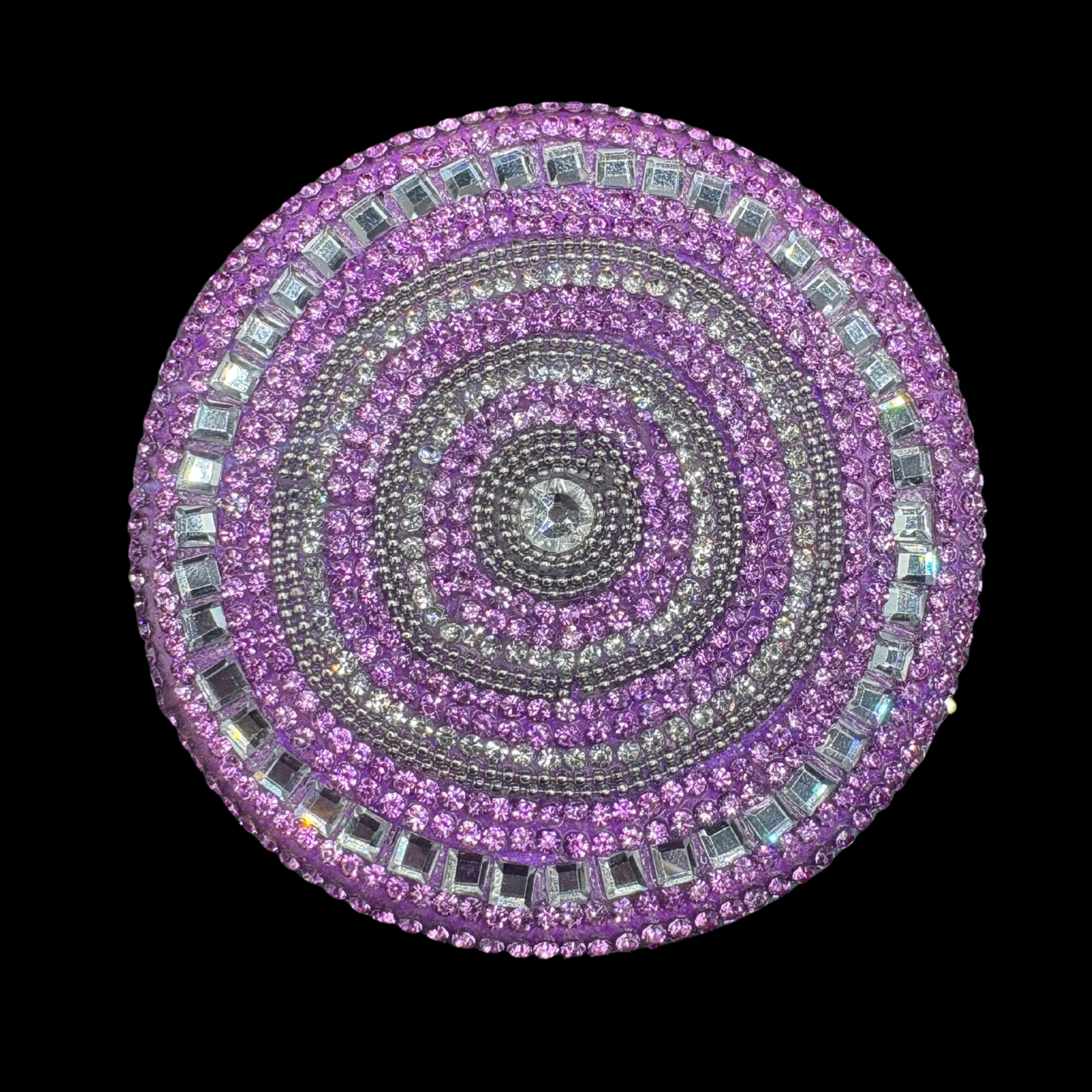 Circular purple and silver jeweled object on a black background