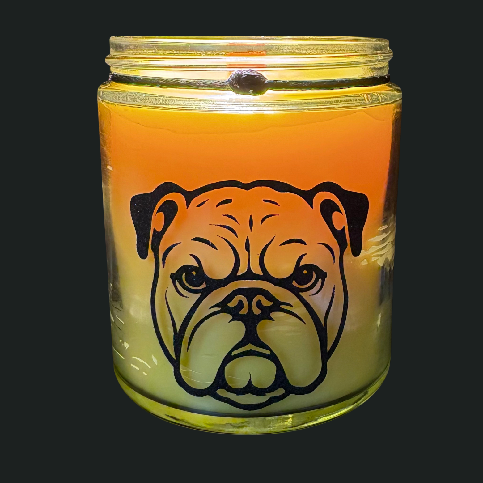 Candle in a glass jar with a bulldog design on a black background
