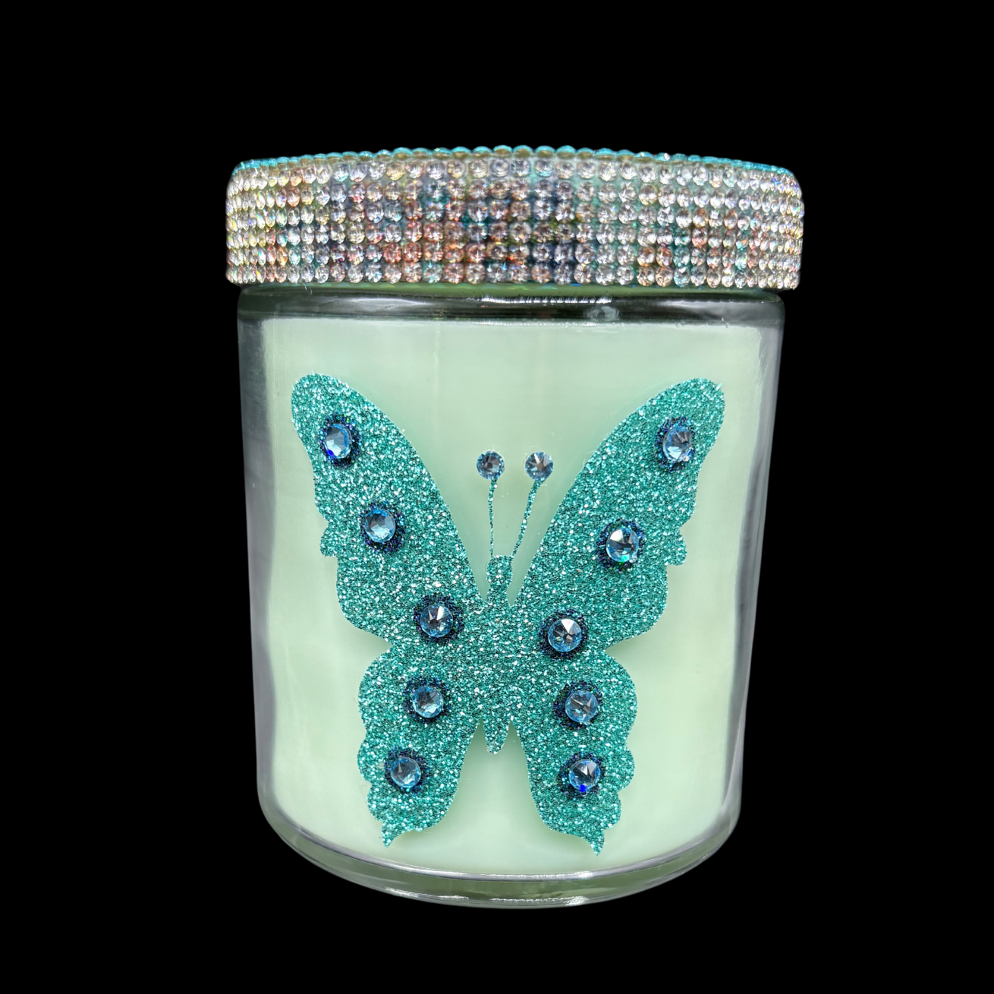 Candle jar with a decorative butterfly design and rhinestone lid on a black background
