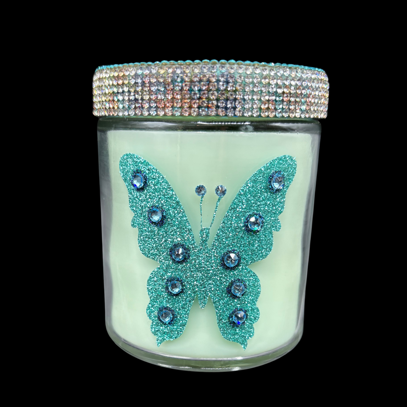 Candle jar with a decorative butterfly design and rhinestone lid on a black background