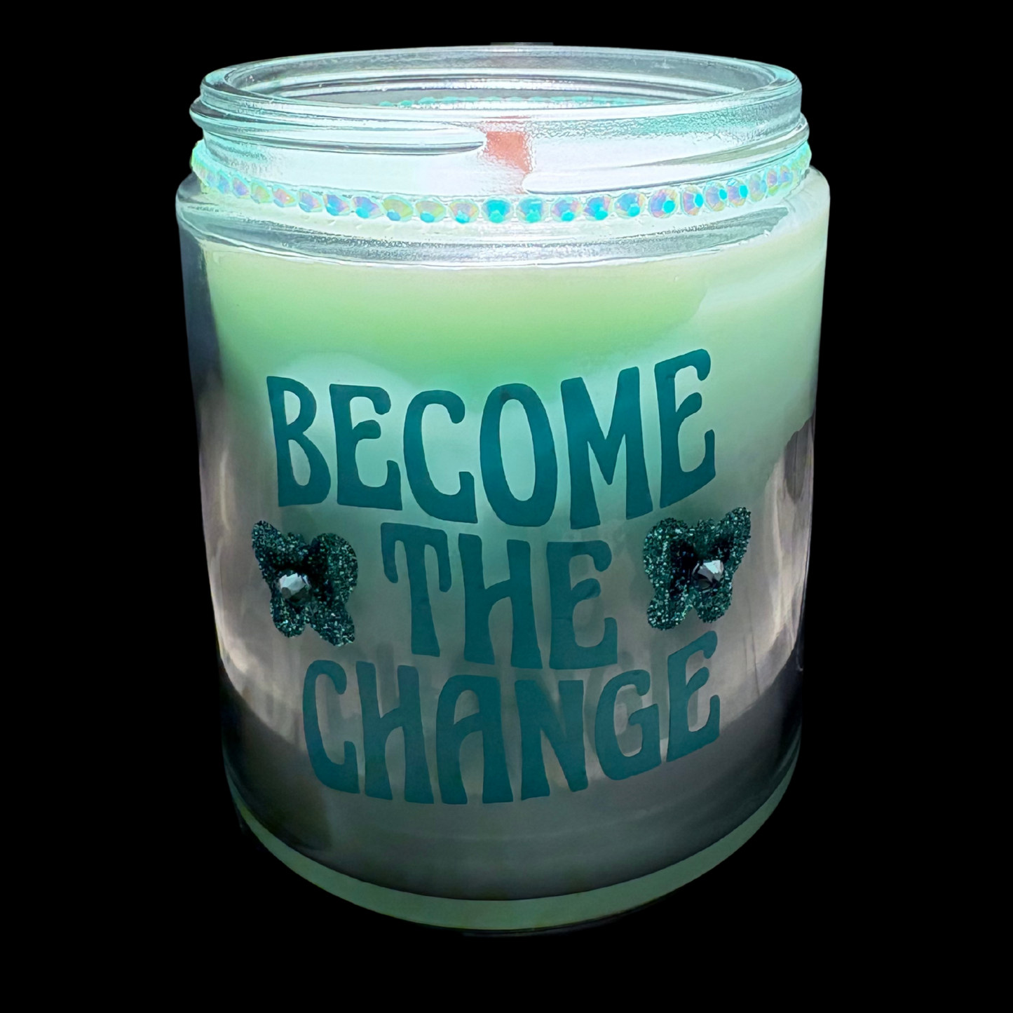 Candle in a jar with 'BECOME THE CHANGE' text on a black background