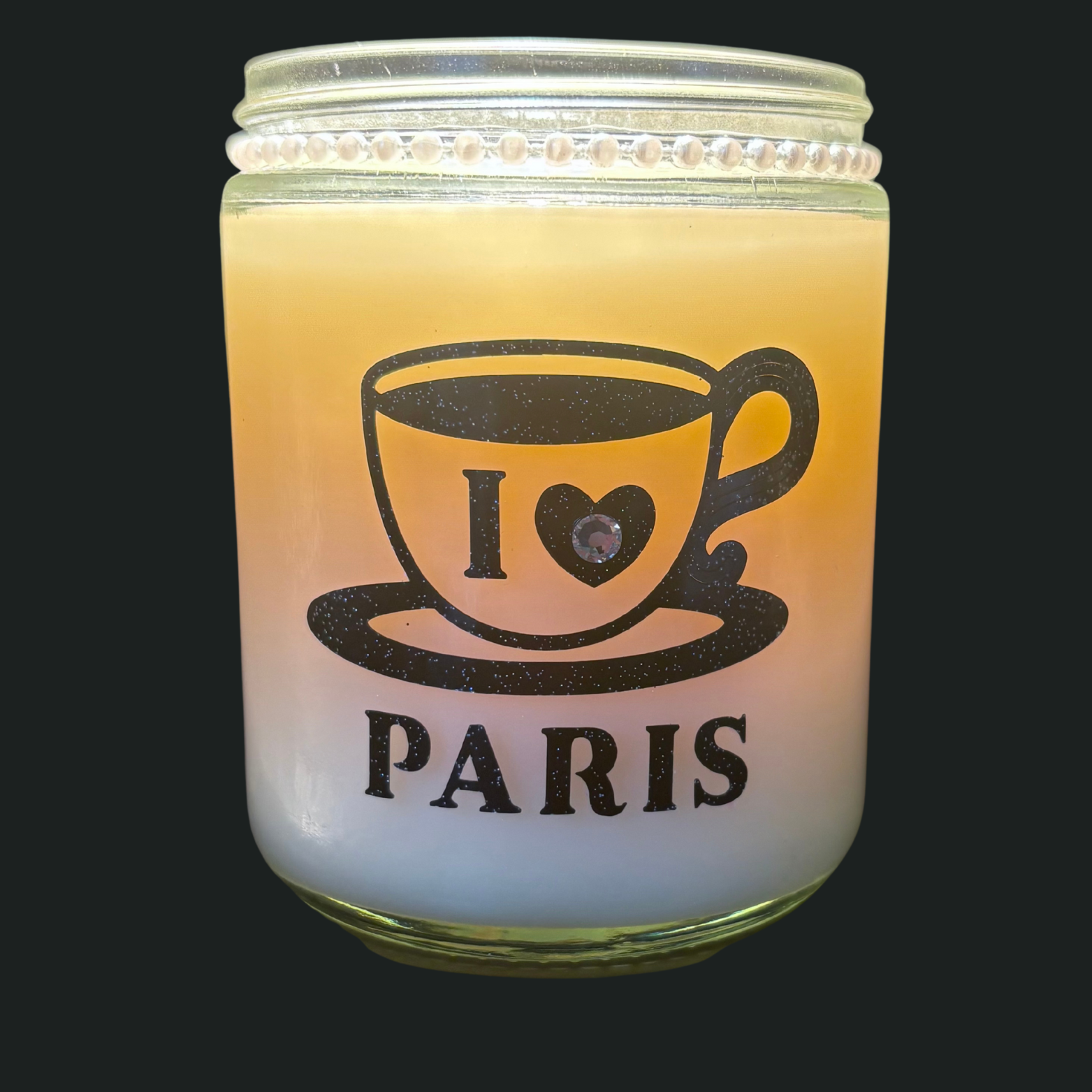 Candle in a glass jar with 'I ❤️ PARIS' text on a black background