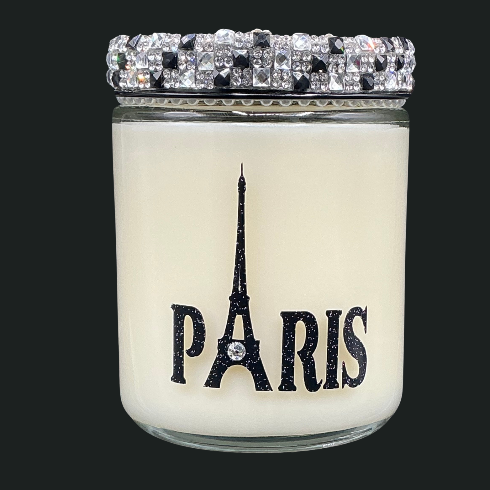 Candle with Eiffel Tower design and 'Paris' text on a black background