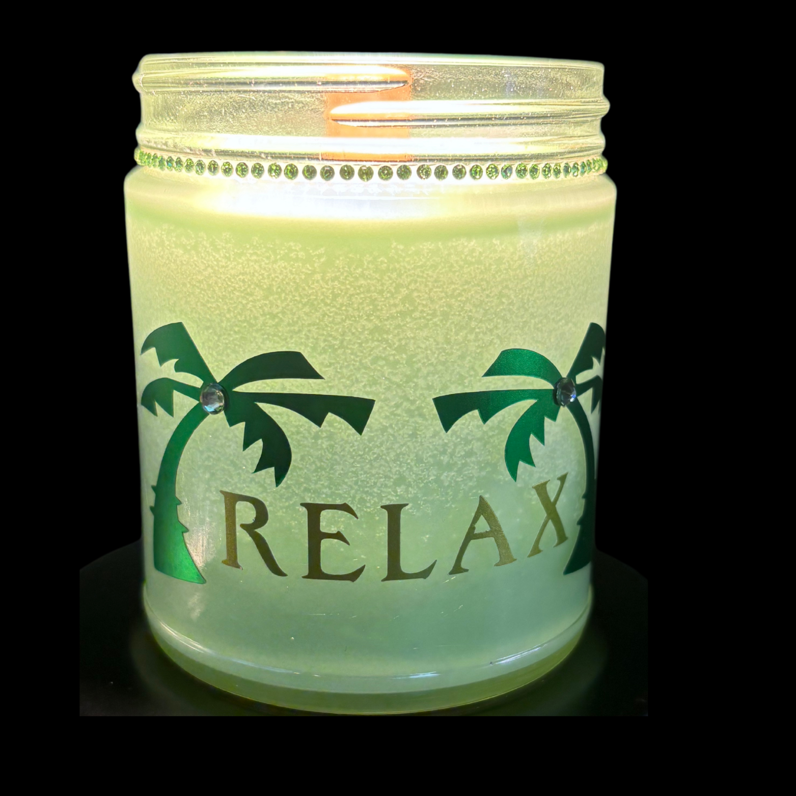 Candle in a jar with 'RELAX' and palm tree designs on a black background