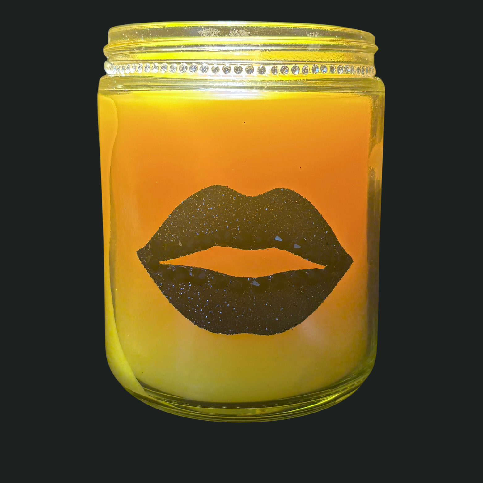 Candle in a jar with a silhouette of lips on a black background