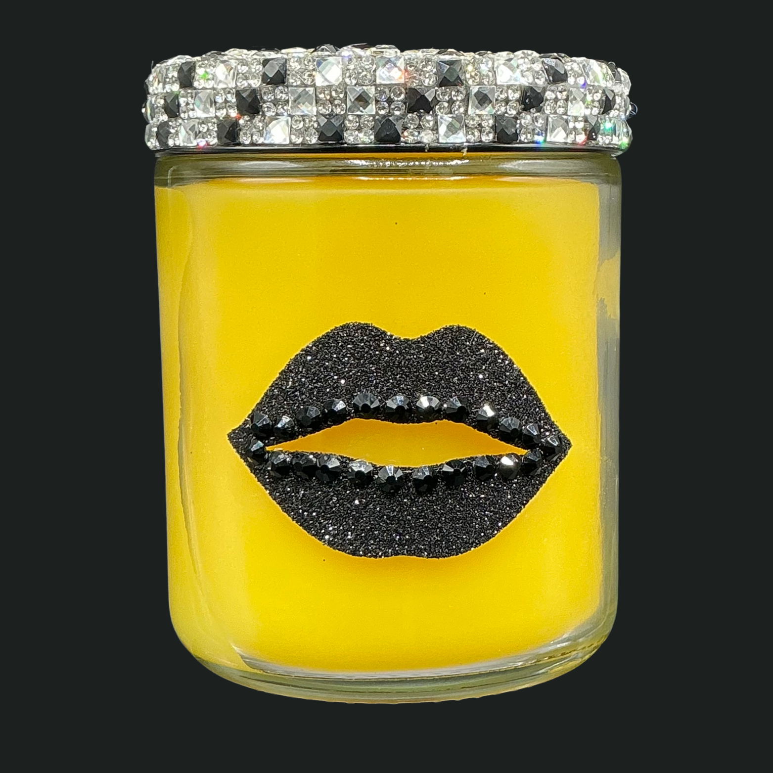 Yellow candle in a glass jar with black lip design and crystal lid on a black background