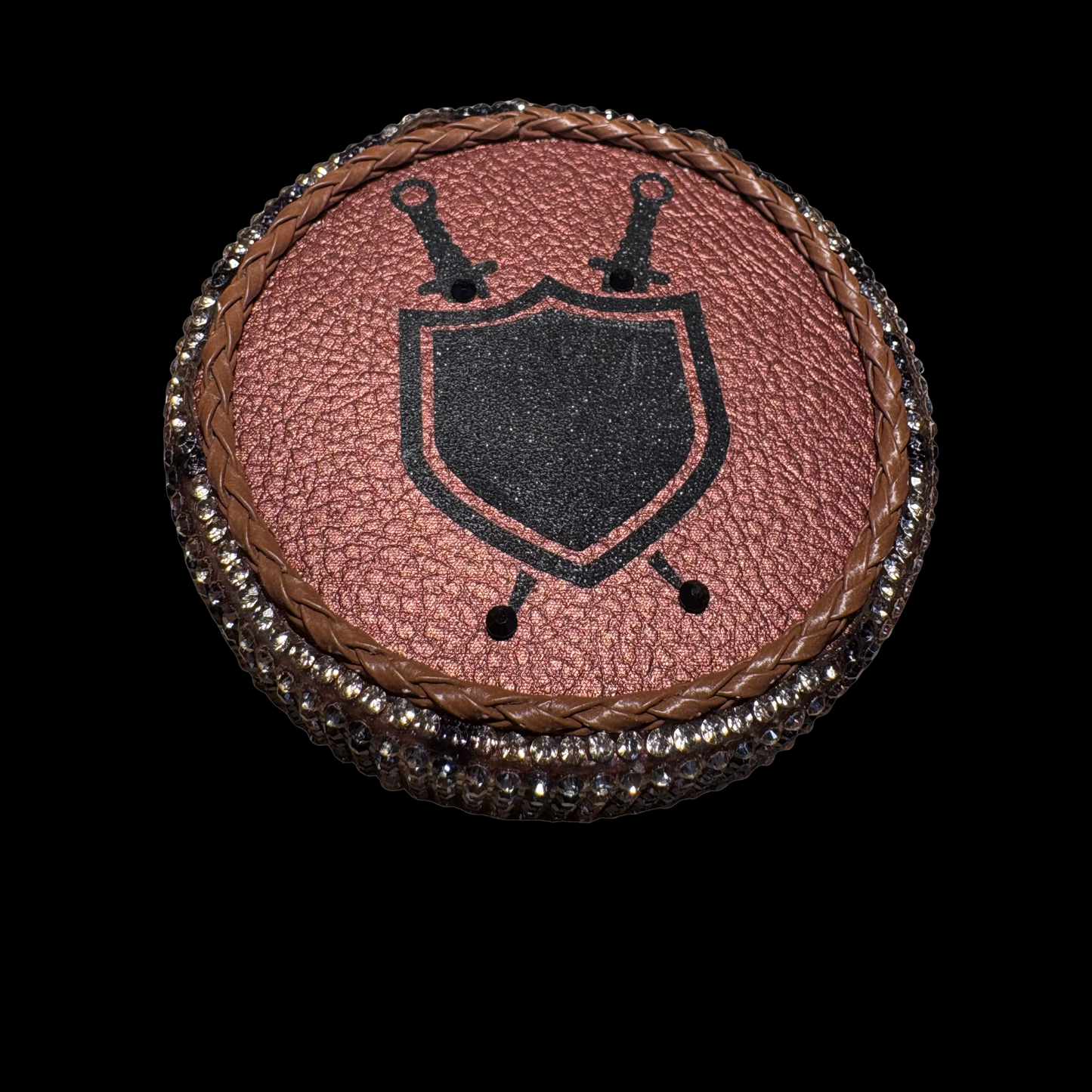 Round leather patch with a black shield design on a brown background
