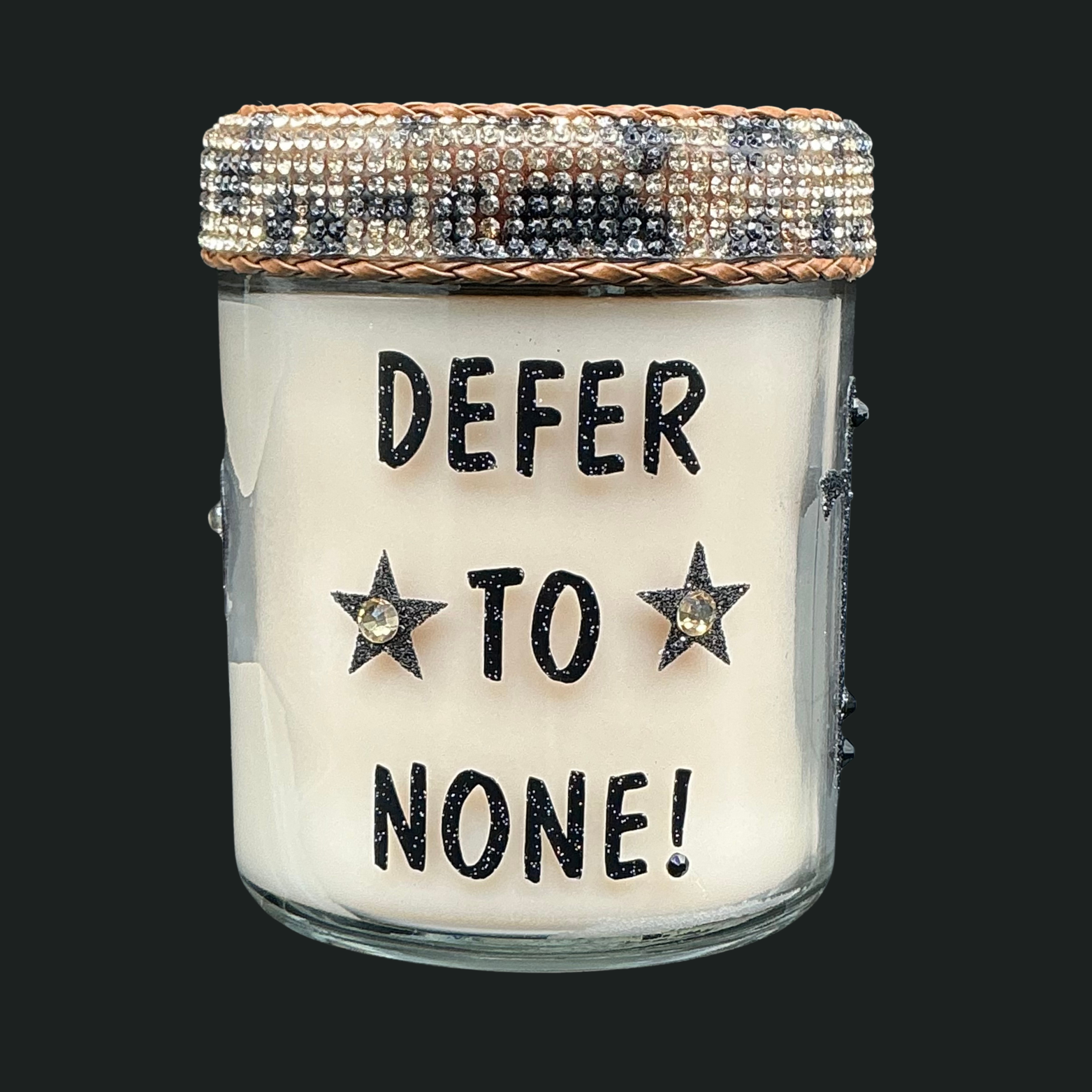 Candle jar with text 'Defer to None!' on a black background