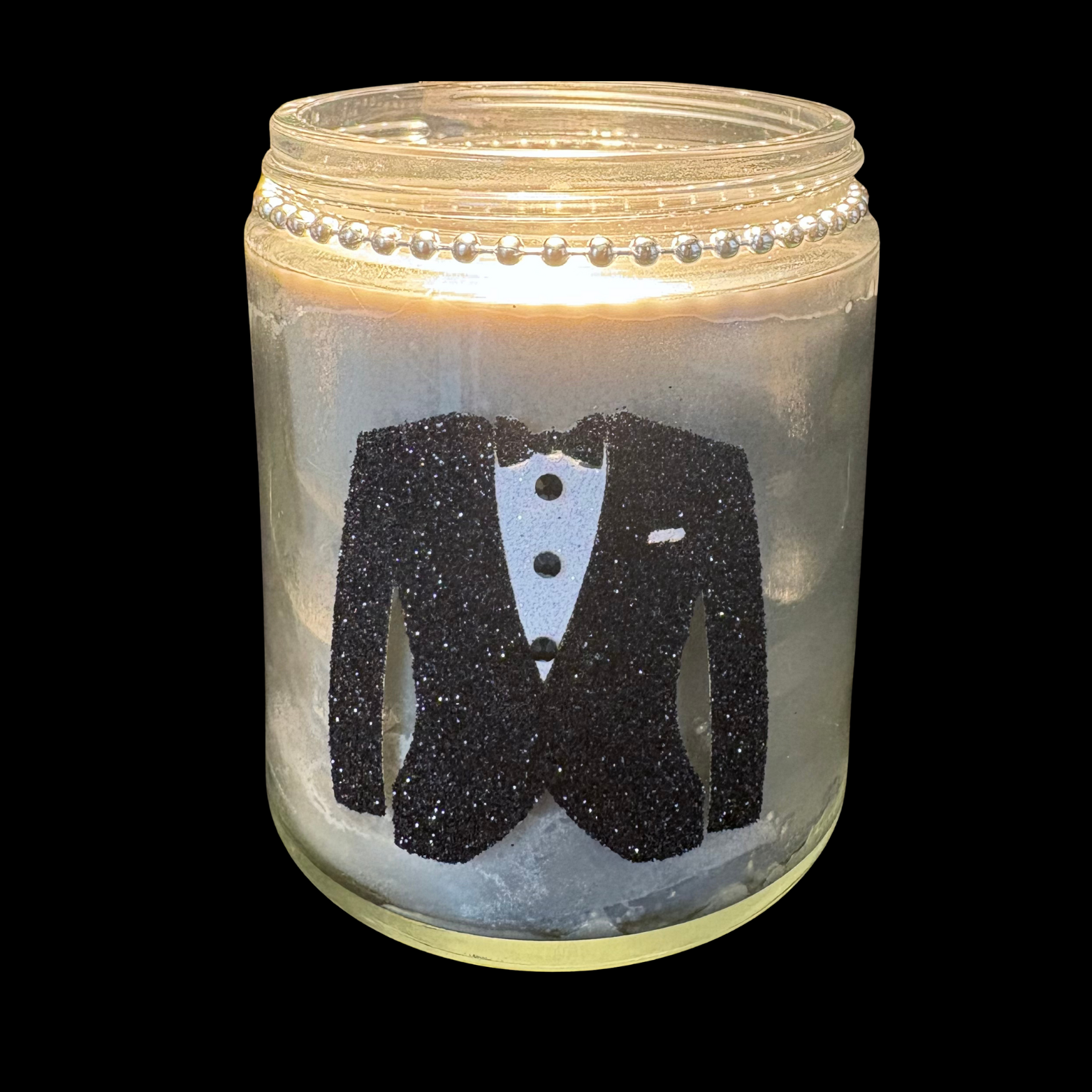 Candle in a jar with a tuxedo design on a black background