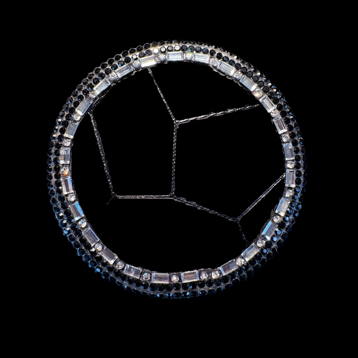 Decorative steering wheel cover with black and silver stones on a black background