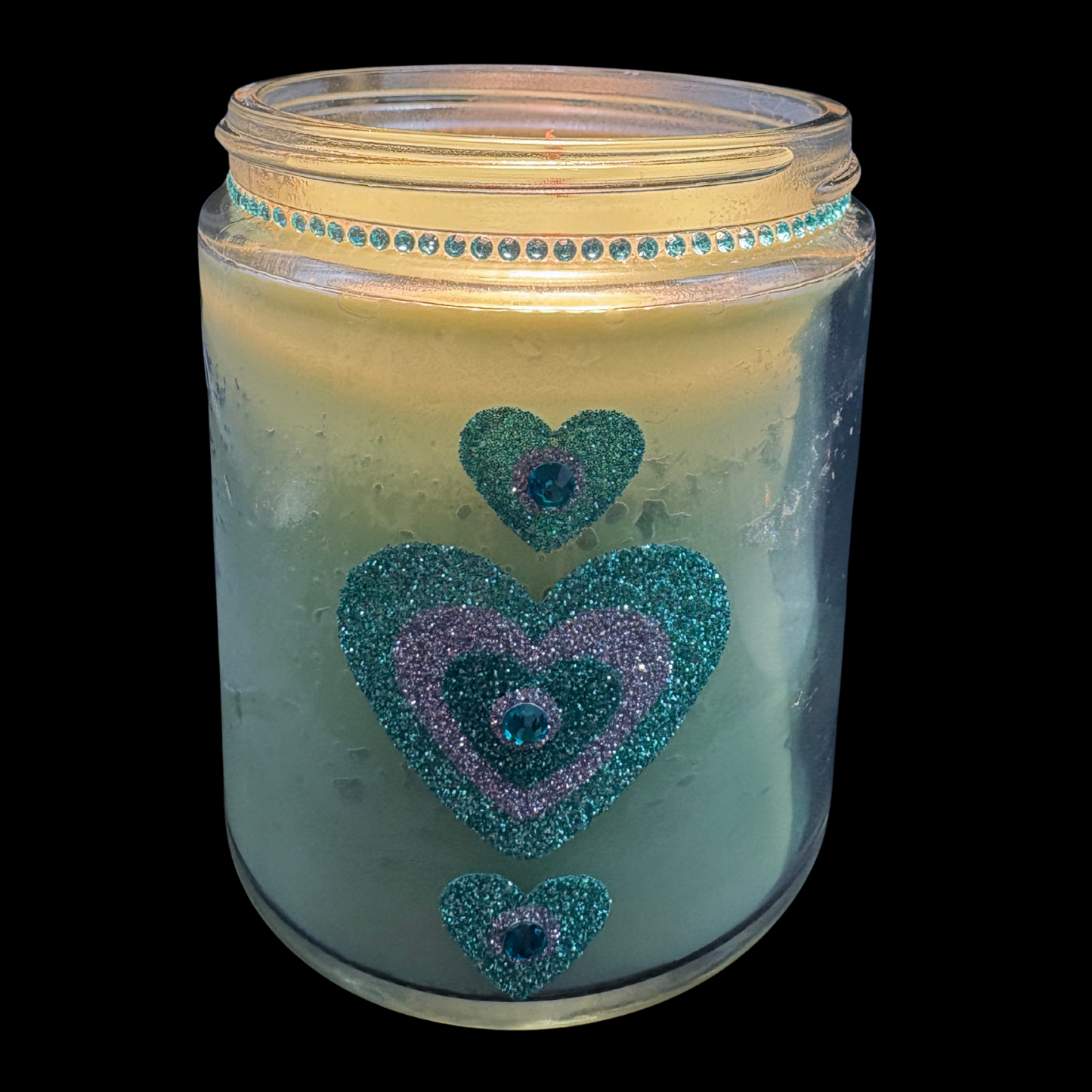 Candle in a jar with decorative hearts on a black background