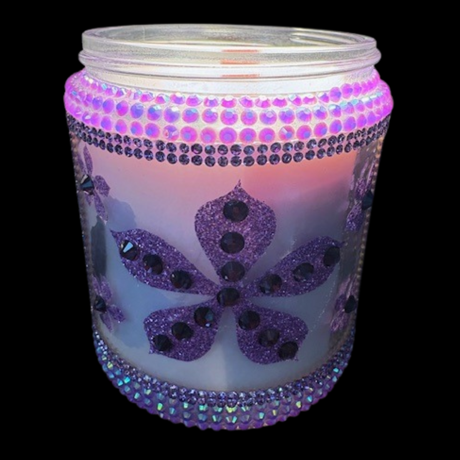 Decorative candle in a jar with purple and black embellishments on a white background