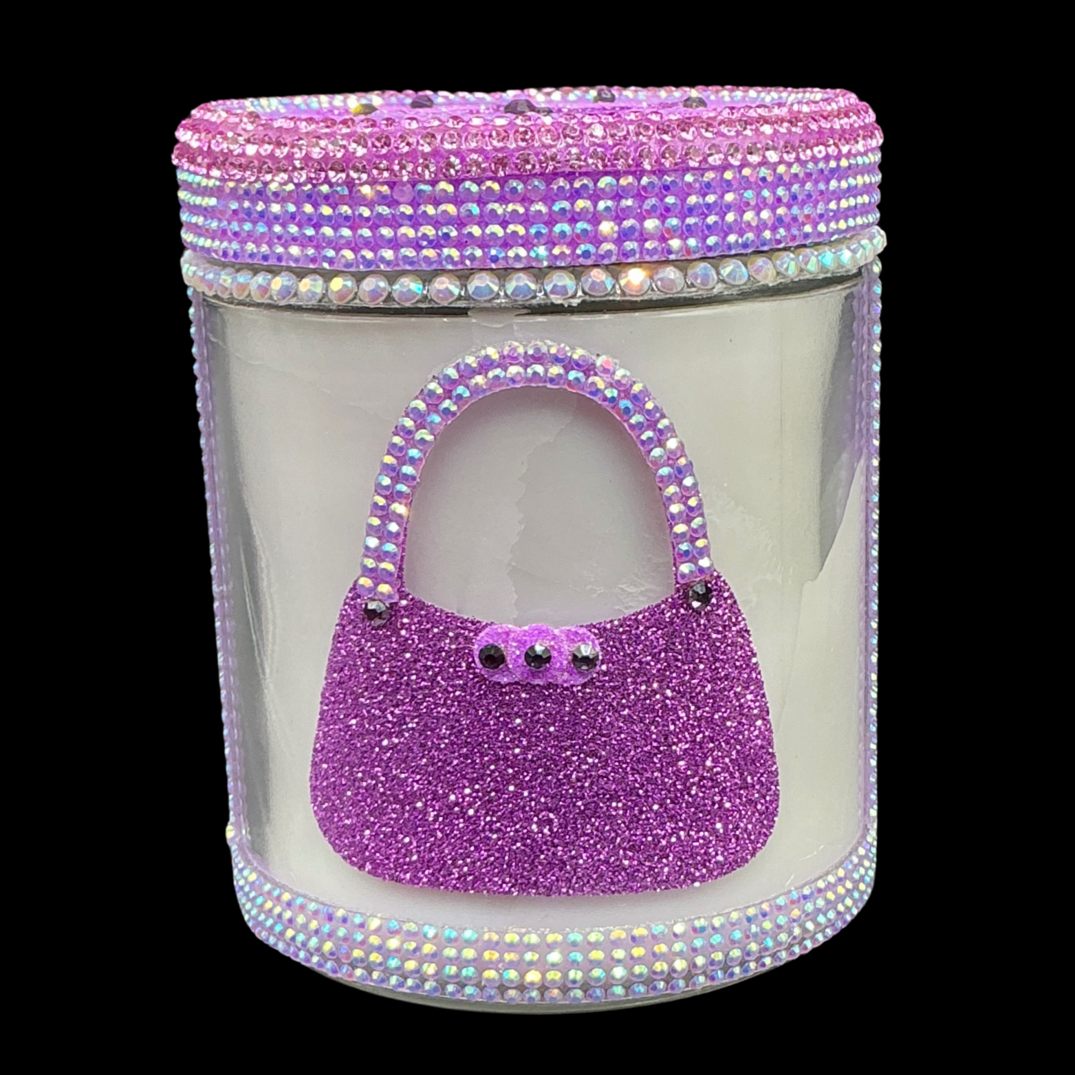 Decorative candle with a purple handbag design and rhinestone embellishments on a clear background