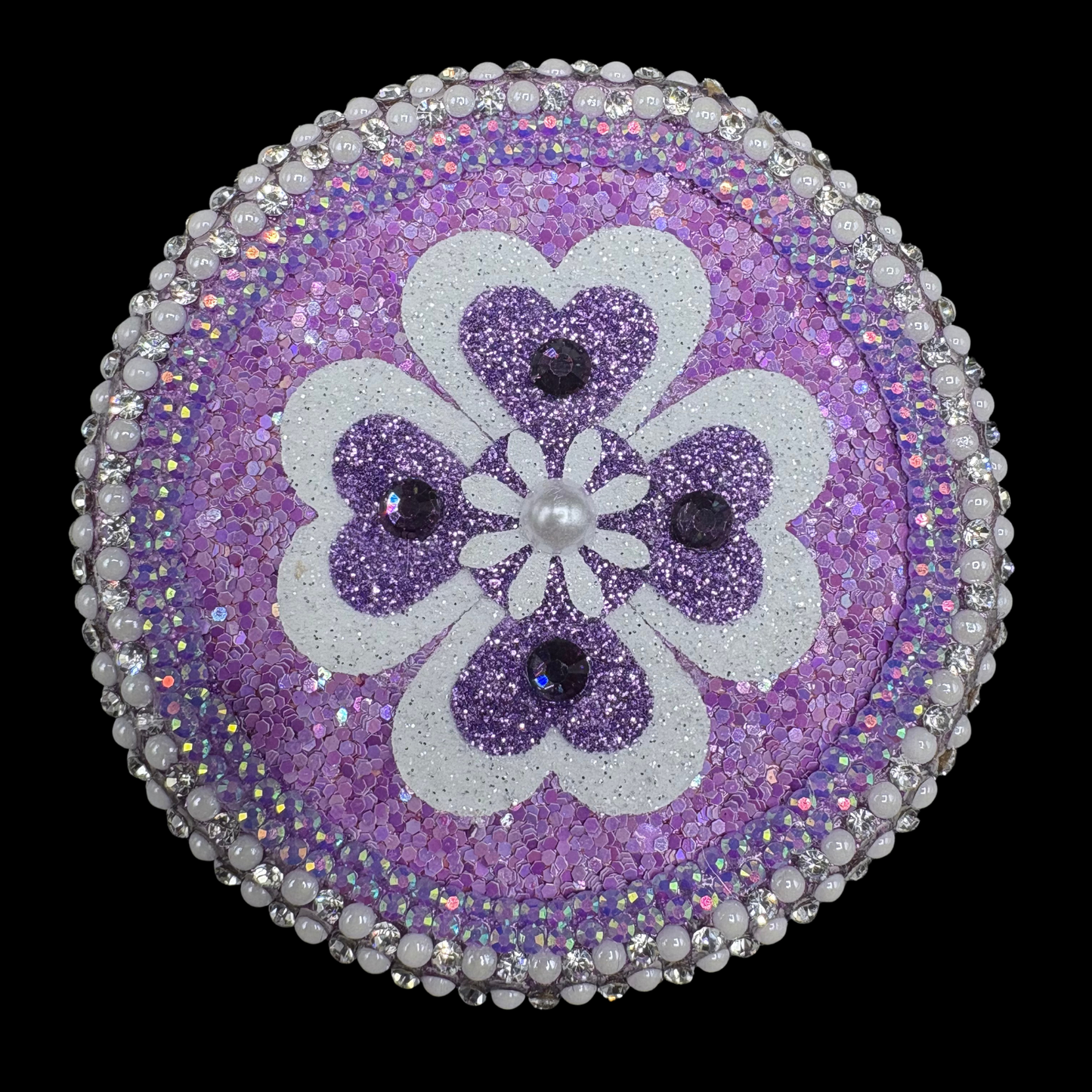 Purple and white hearts and flower on black background.