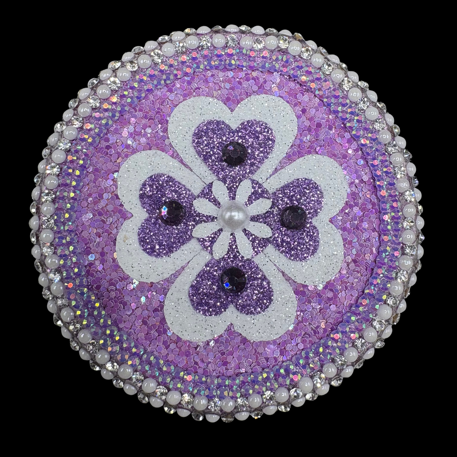 Purple and white hearts and flower on black background.