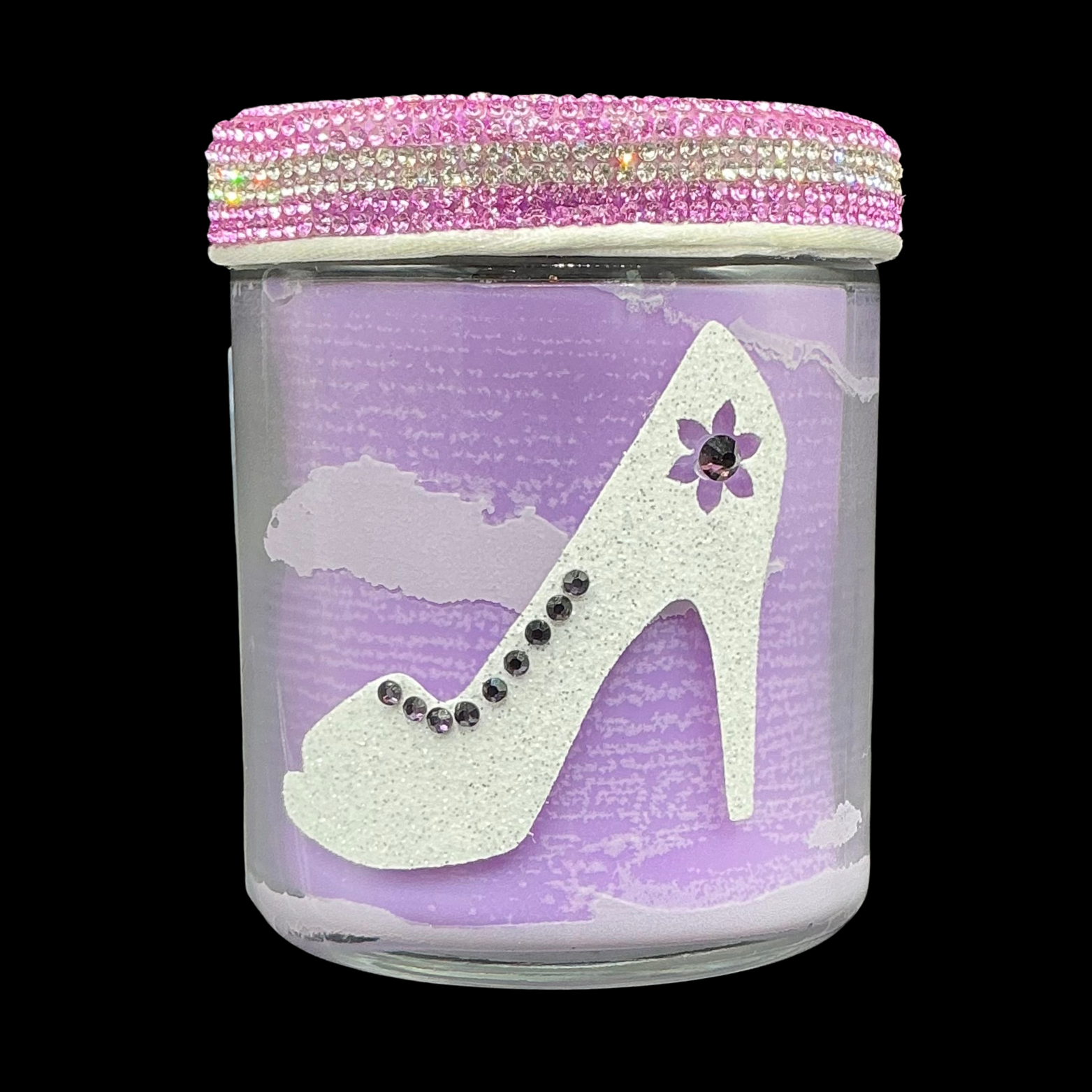 Decorative candle jar with high heel shoe design and pink lid on a black background