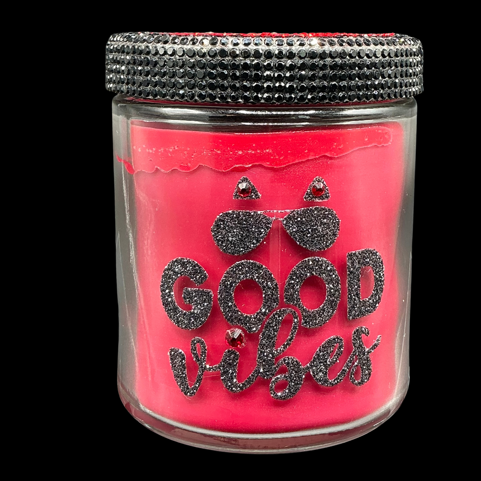 Pink candle jar with 'Good Vibes' text and decorative lid on a black background