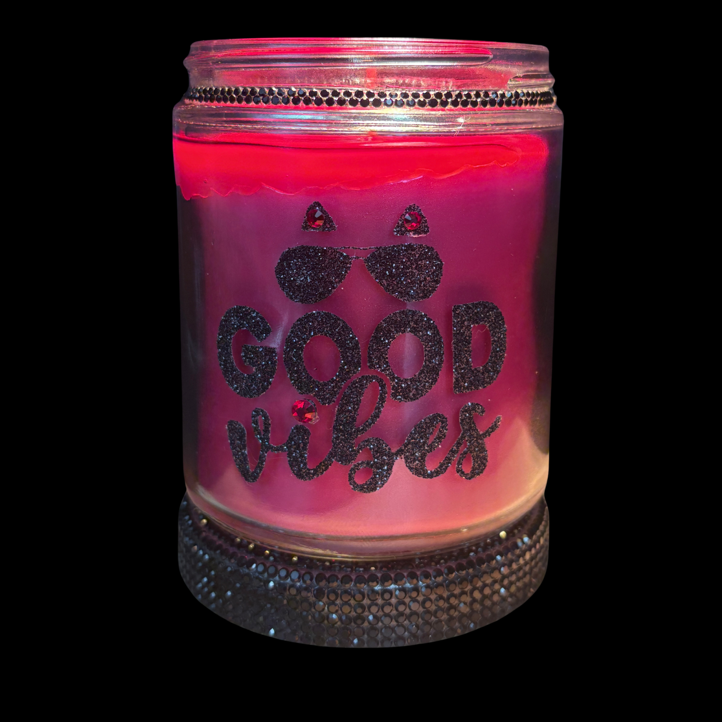 Pink candle in a jar with 'Good Vibes' text on a black background