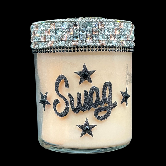 Candle in a glass jar with 'Swag' and star designs, topped with a rhinestone lid.
