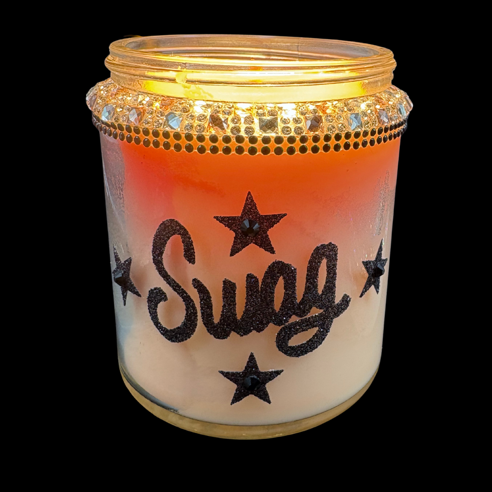 Candle in a jar with 'Sugg' text and star designs on a black background