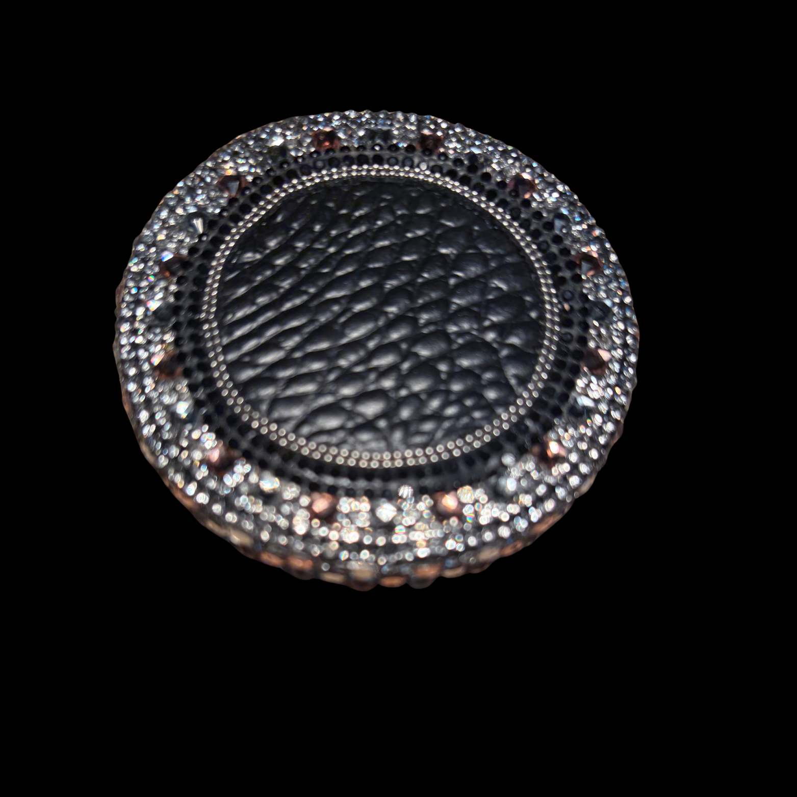 Round black leather product with silver embellishments on a black background