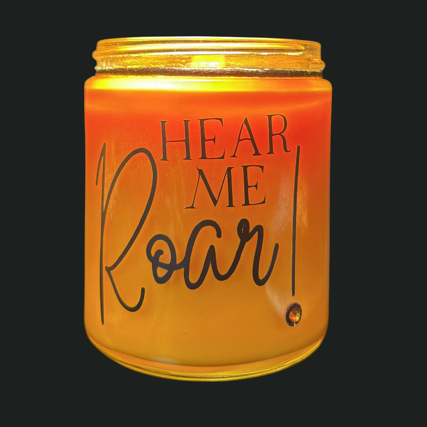 Candle jar with 'HEAR ME ROAR!' text on a black background