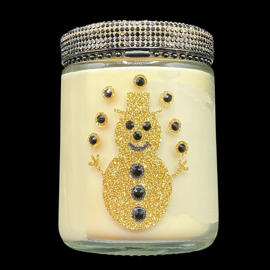 Decorative candle with a gold snowman design on a black background