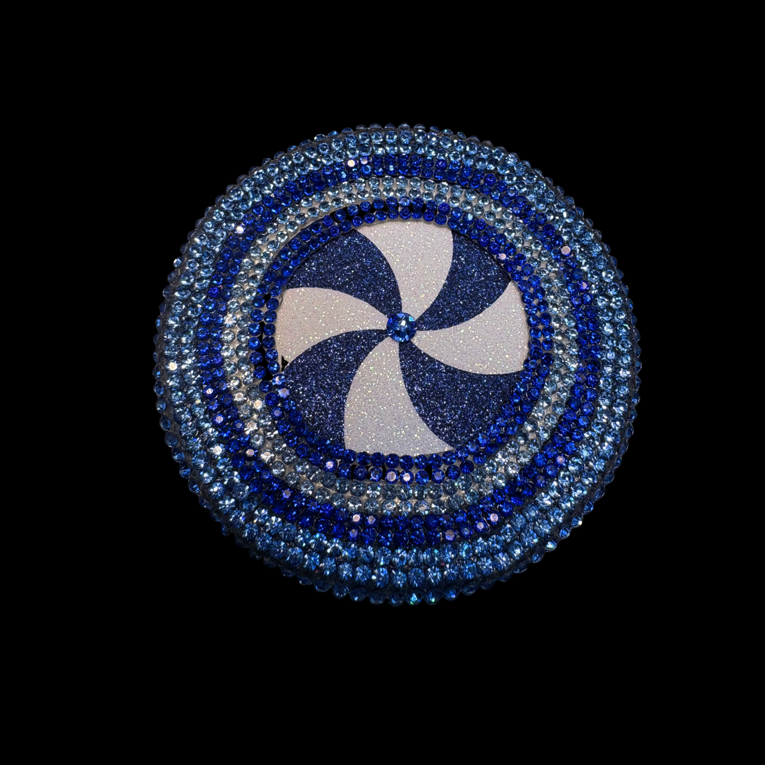 Circular decorative item with blue and silver design on a black background