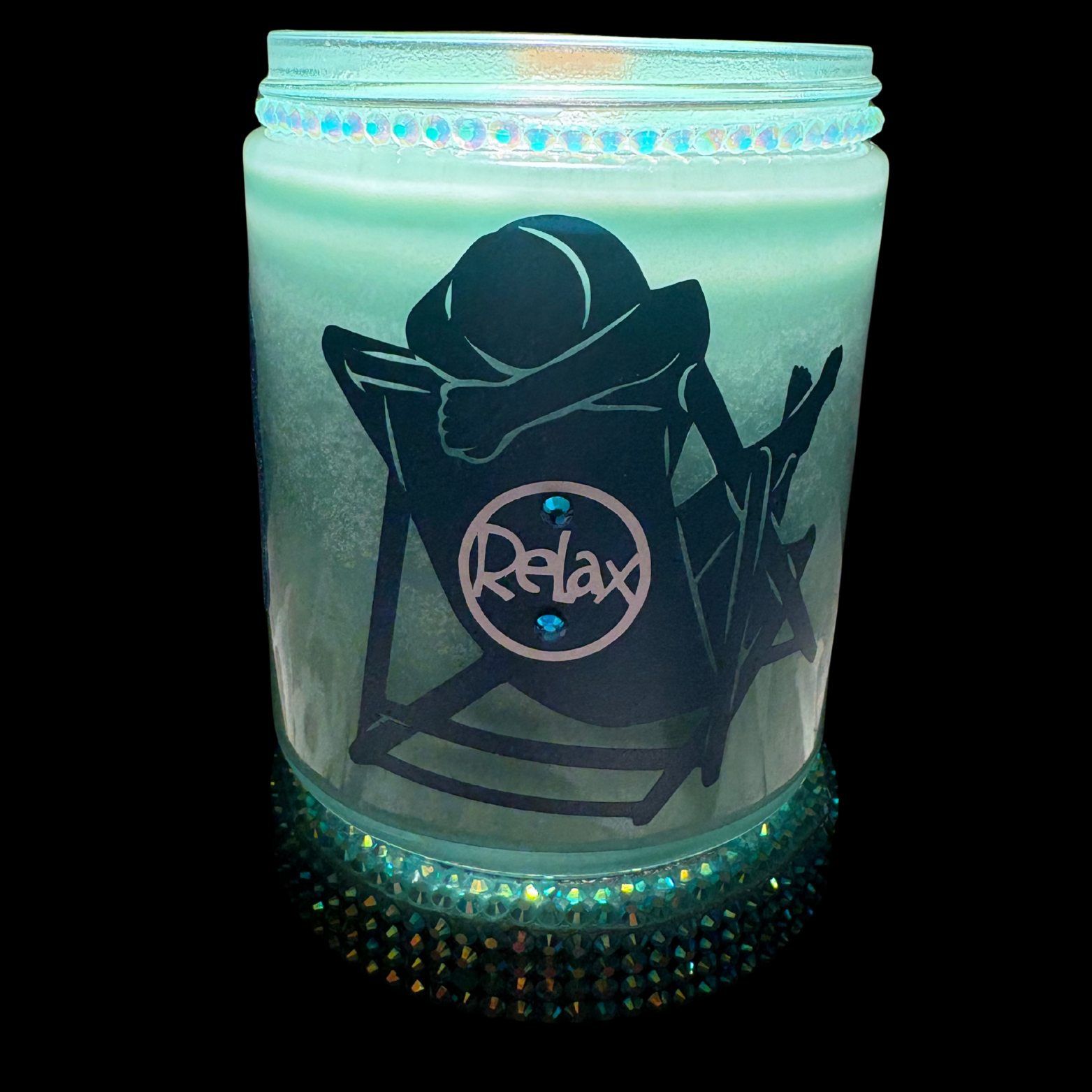 Glowing candle jar with 'Relax' design on a black background