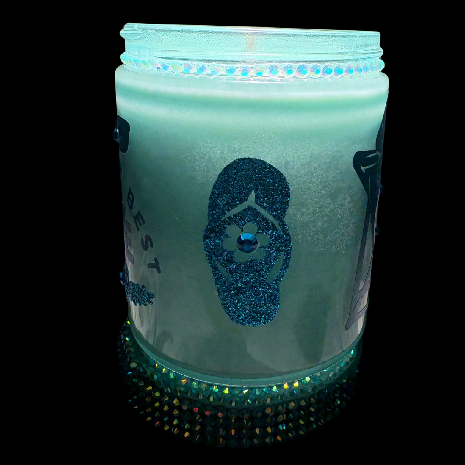 Glowing teal candle with a face design on a black background