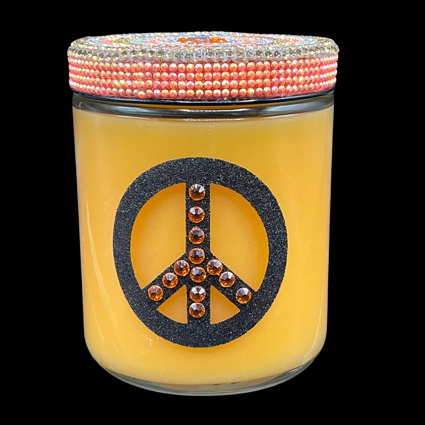 Yellow candle jar with peace symbol and beaded lid on a black background