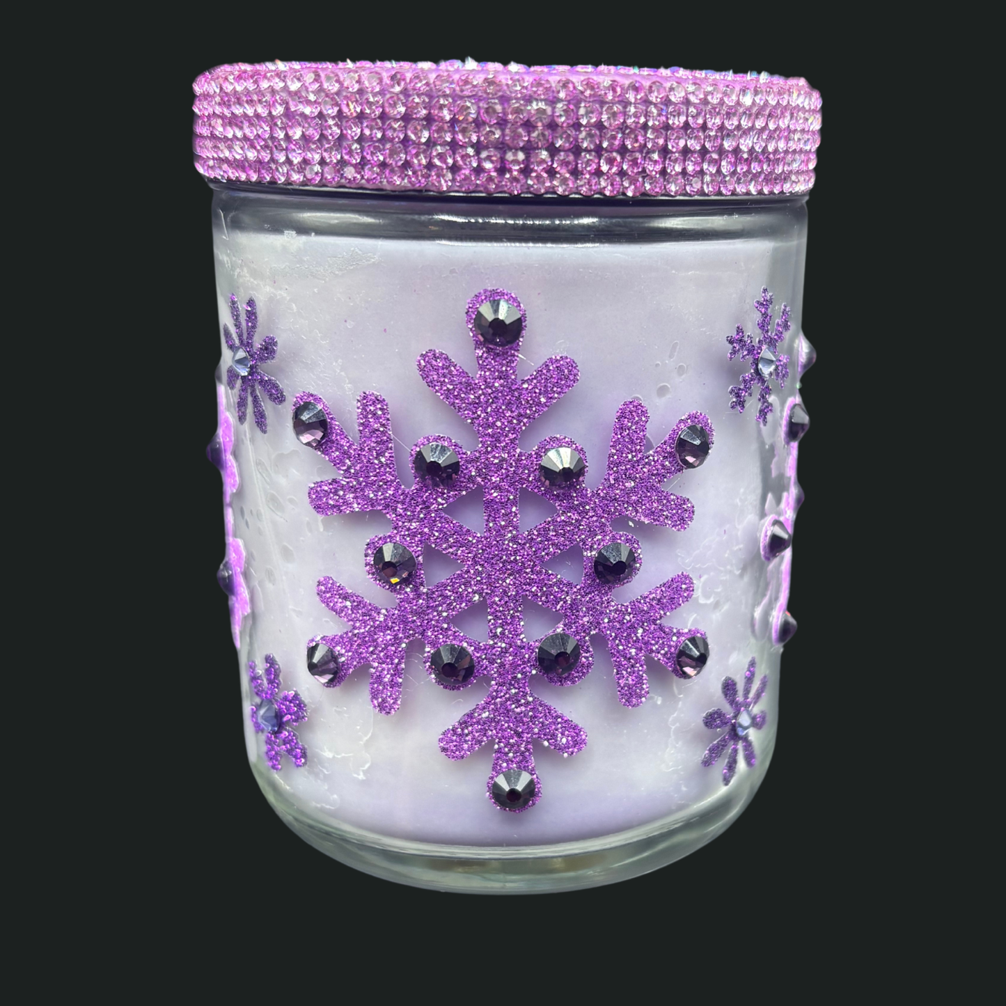 Decorative glass jar with purple snowflakes and crystals on a black background