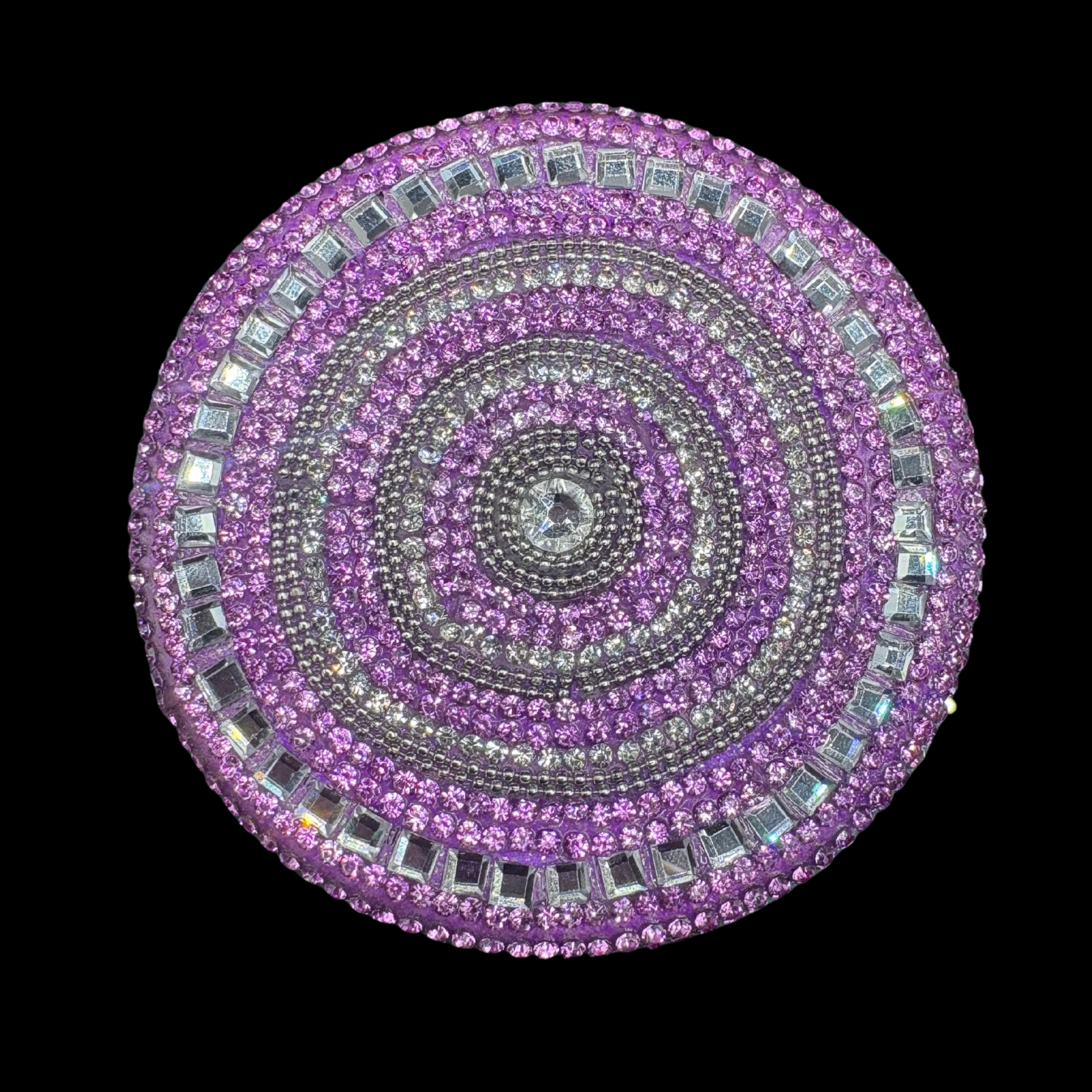Circular purple and silver jeweled object on a black background