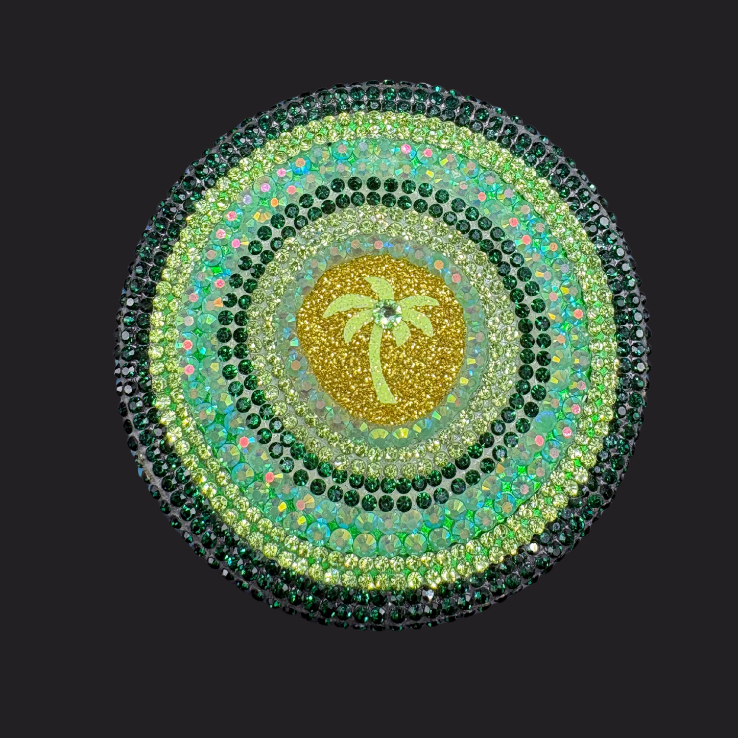 Circular design with a palm tree in the center, surrounded by green and gold colors on a black background.