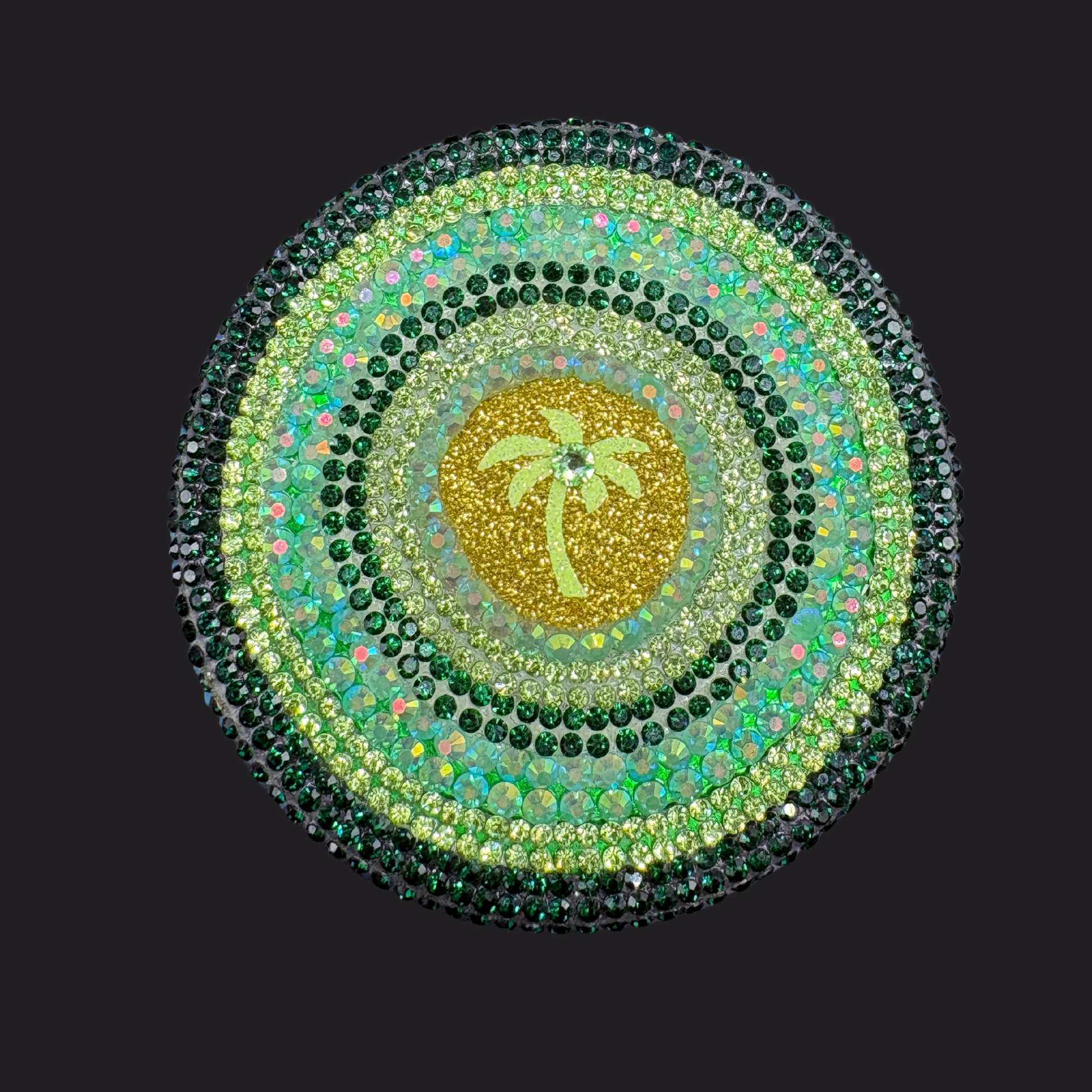 Circular design with a palm tree in the center, surrounded by green and gold colors on a black background.