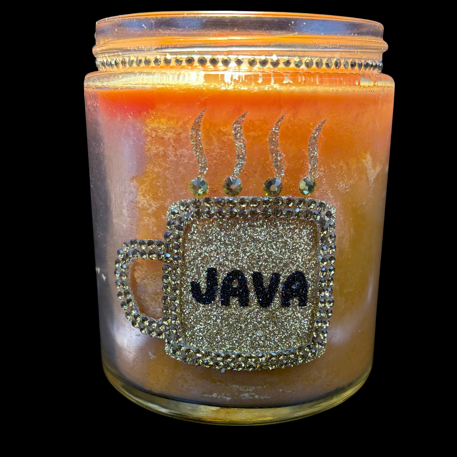 Candle jar with 'JAVA' design and decorative elements on a black background