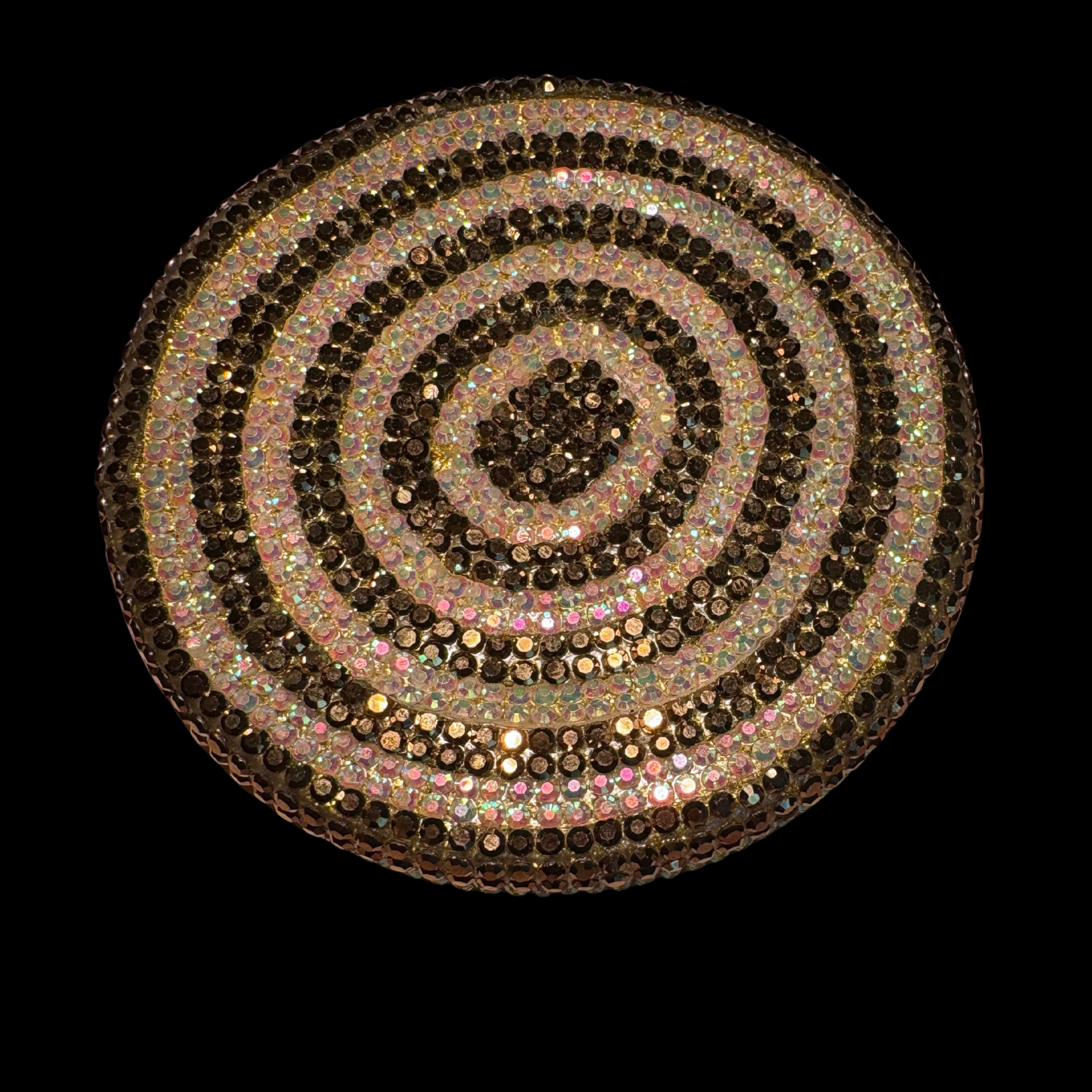 Decorative circular object with multicolored stones on a black background