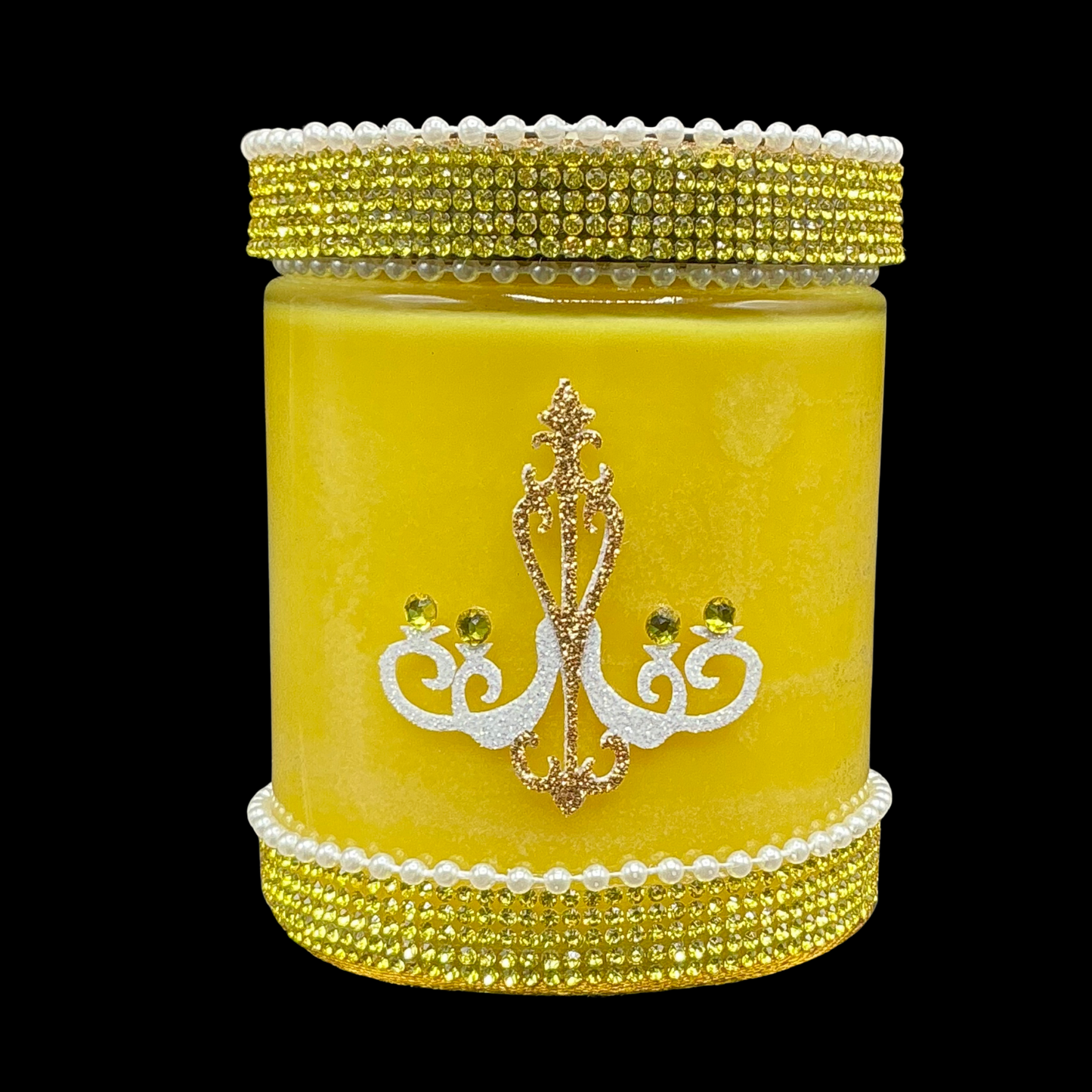 Yellow candle with decorative lid and base on a black background