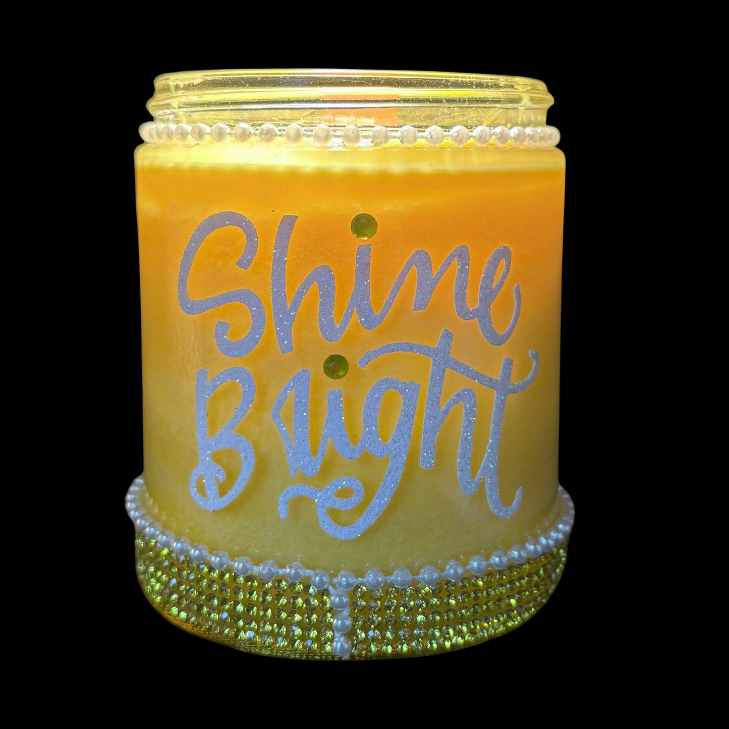 Decorative candle with 'Shine Bright' text on a black background