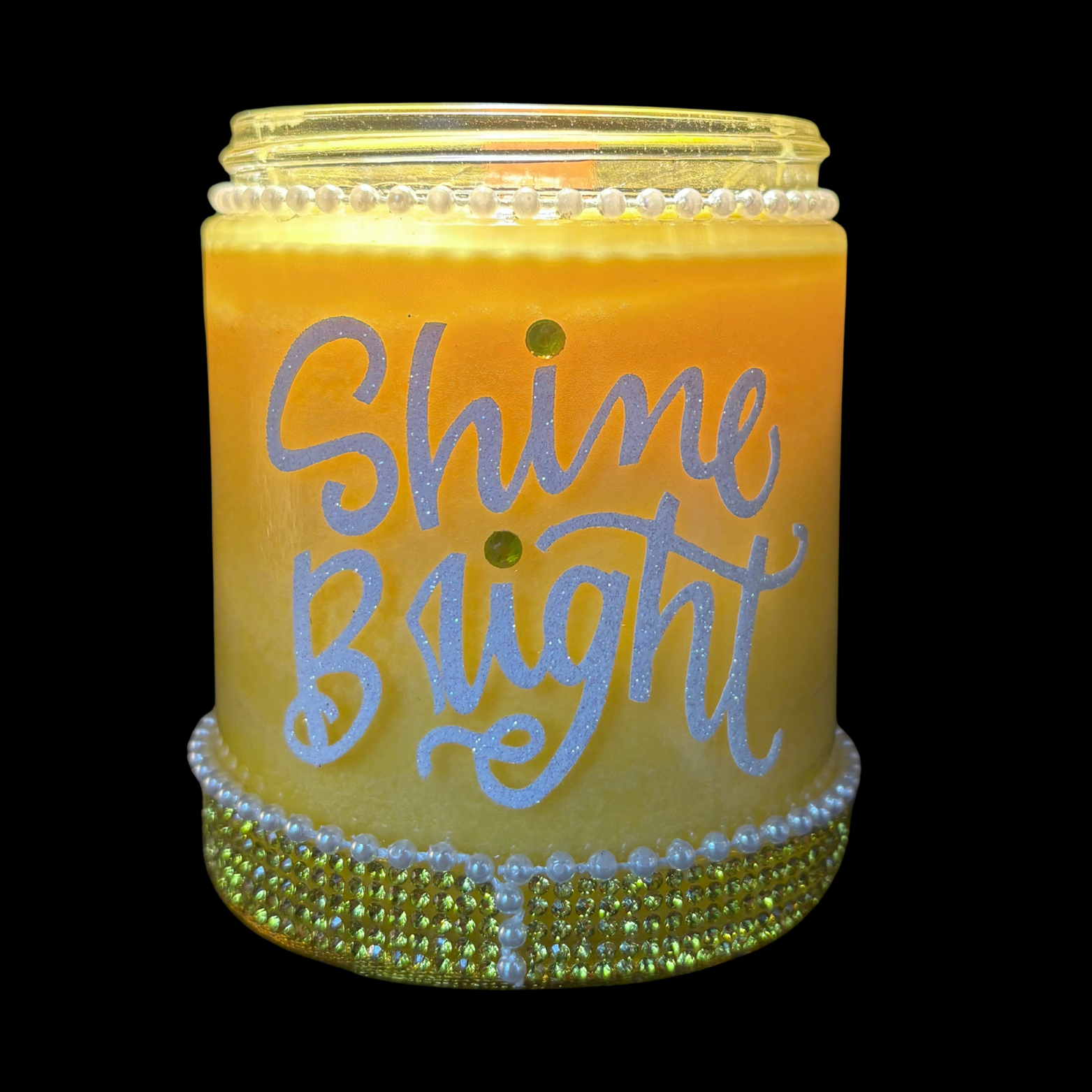 Decorative candle with 'Shine Bright' text on a black background