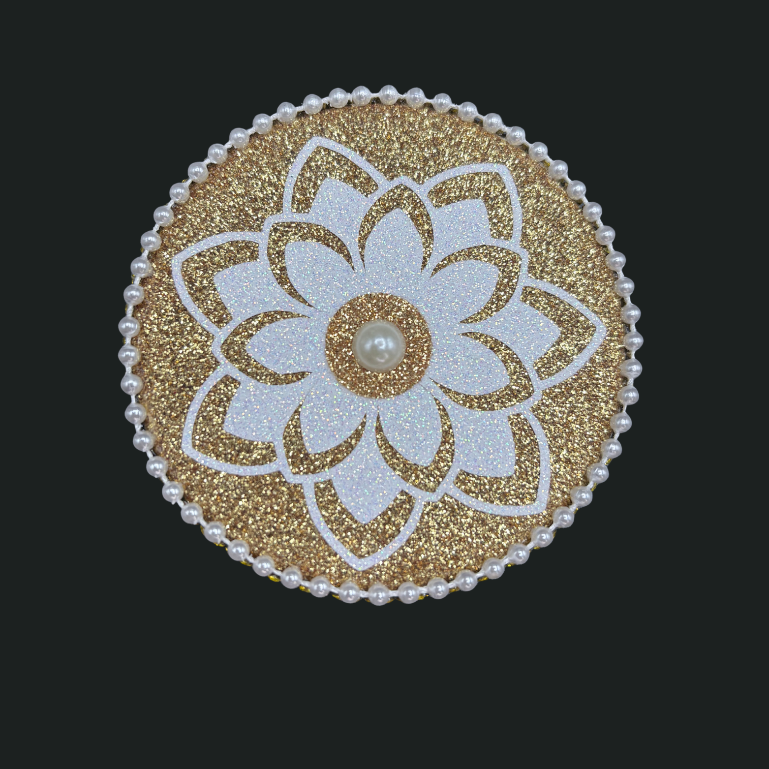 Decorative circular patch with floral design and pearl center on a black background