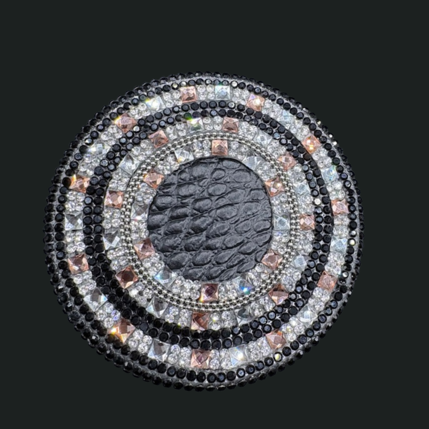 Decorative circular object with multicolored stones on a black background