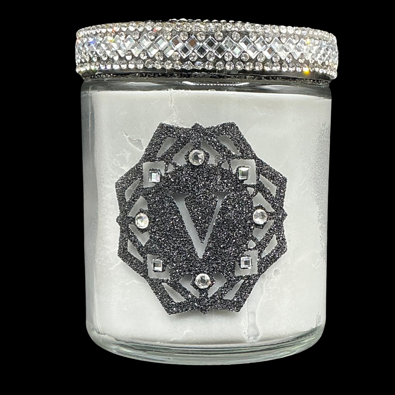 Glass jar with decorative lid featuring a logo and crystals on a black background