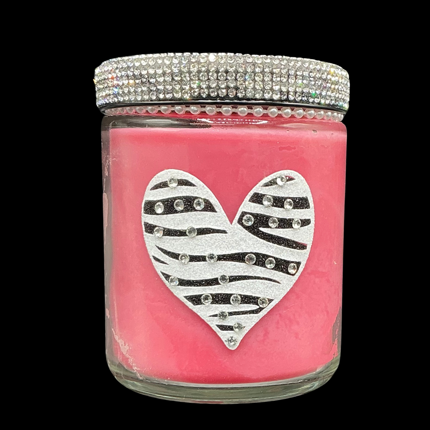 Pink candle jar with a silver zebra-striped heart design and rhinestone lid on a black background