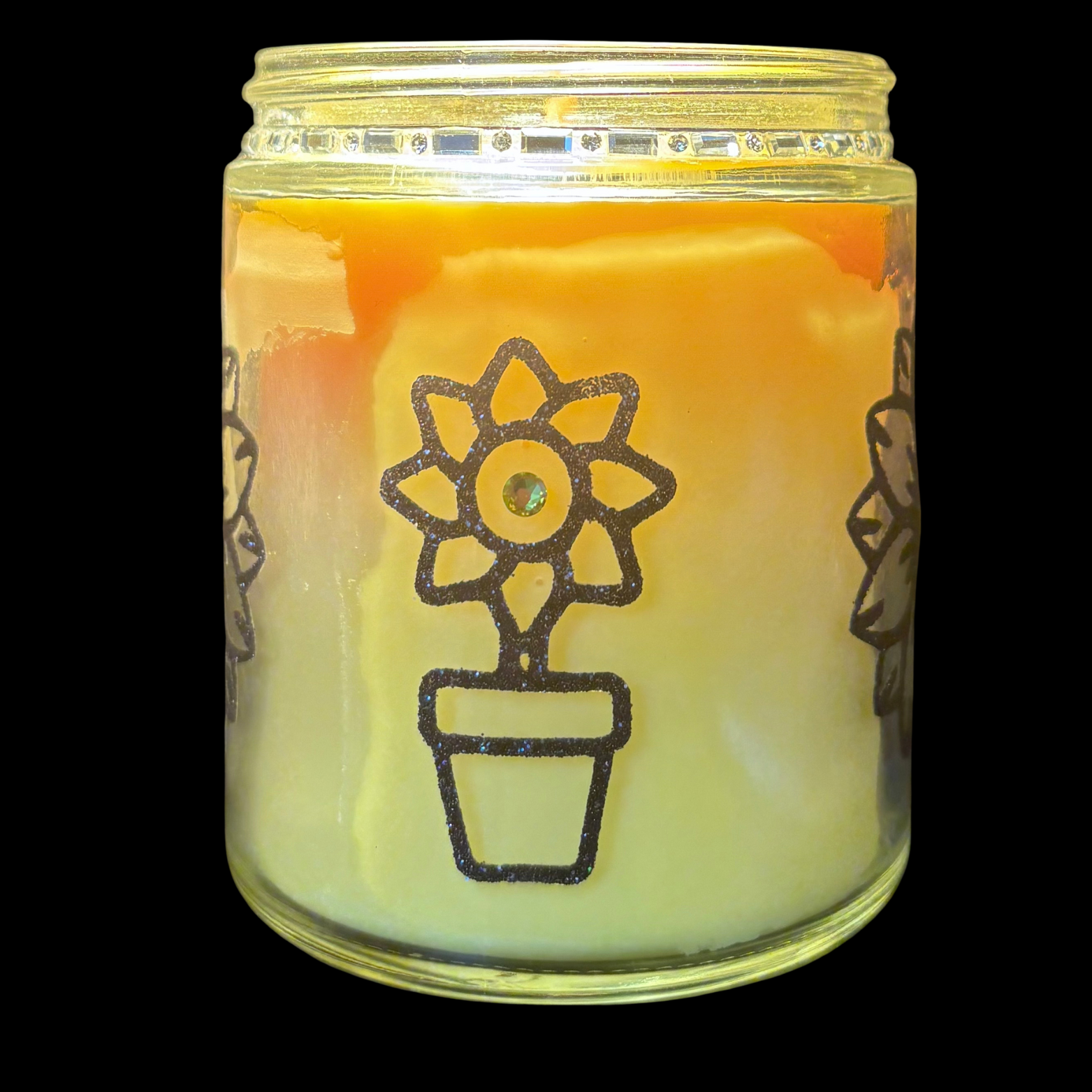 Candle in a glass jar with a flower pot design on a black background