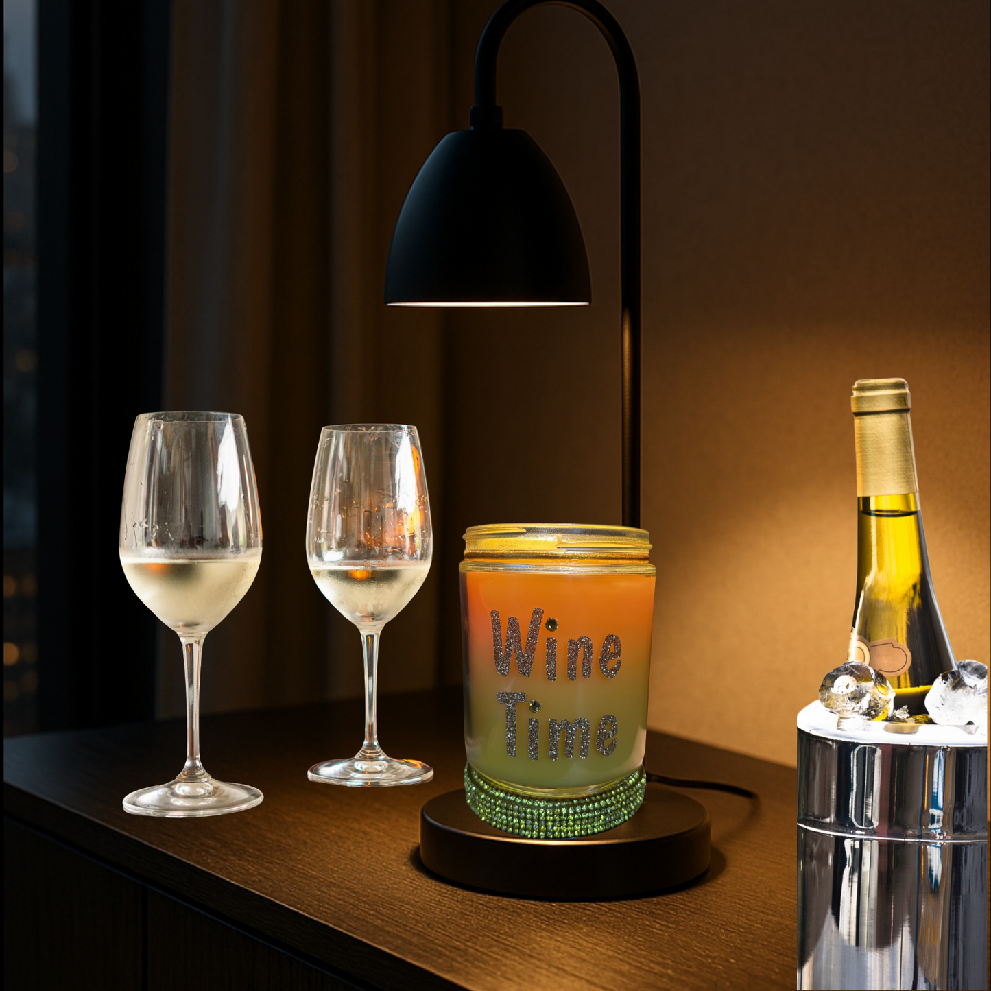 Wine glasses, a candle, and a bottle on a wooden surface with a lamp in the background.