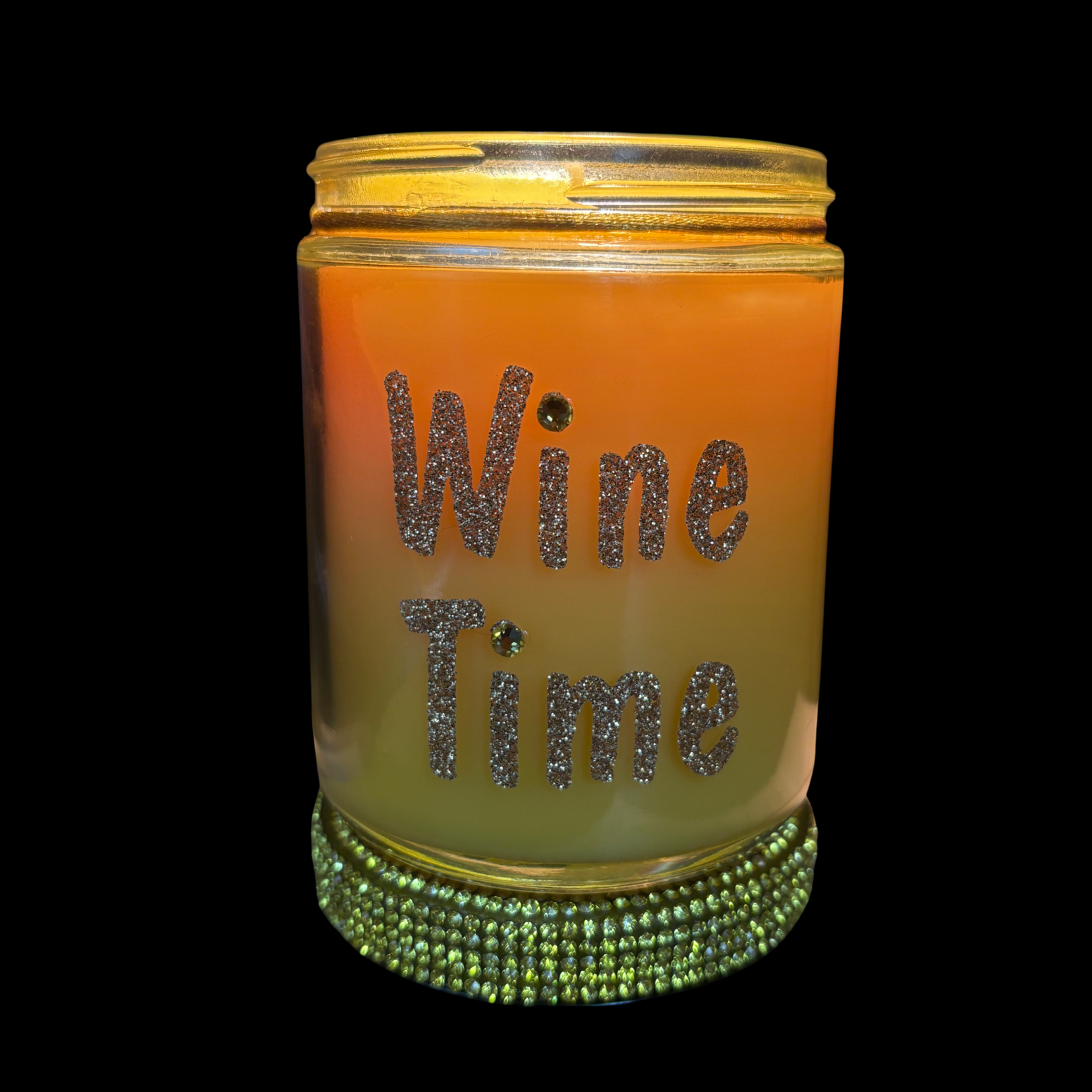 Candle jar with 'Wine Time' text and green gemstone band on a black background